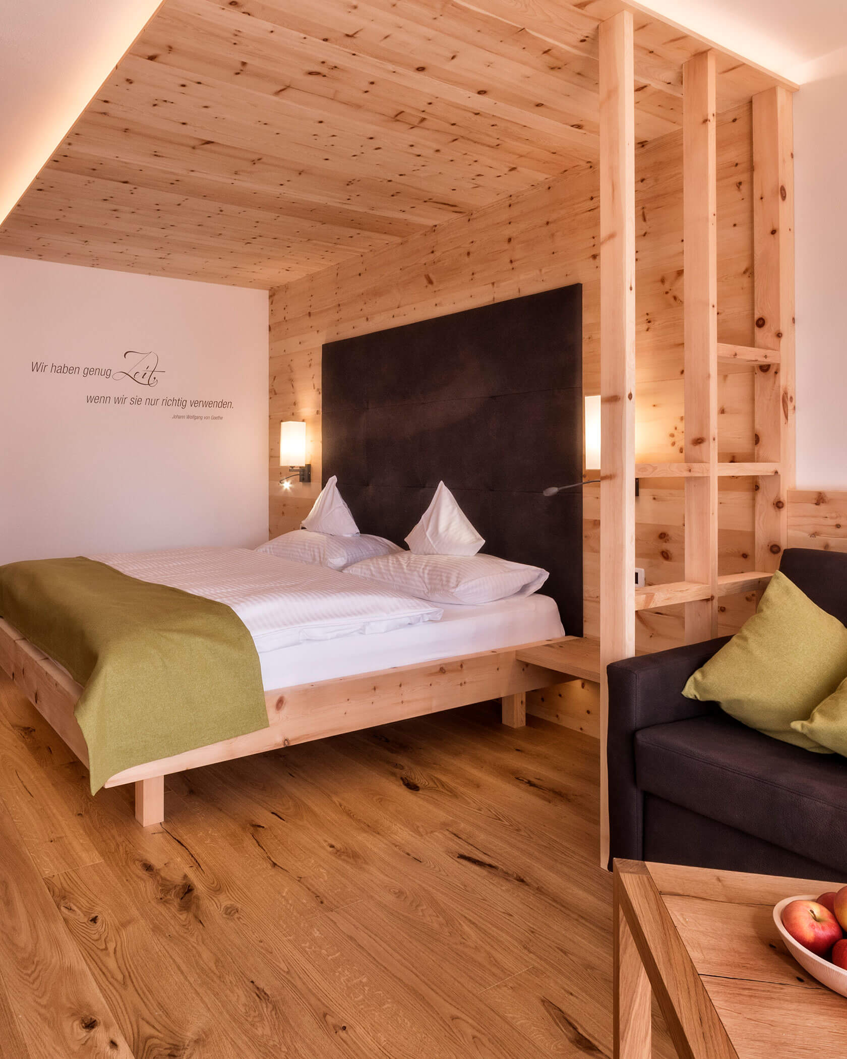 Gemütliches Holzzimmer mit Doppelbett, grüner Decke, schwarzem Kopfteil und sanfter Beleuchtung. - Hotel Sun